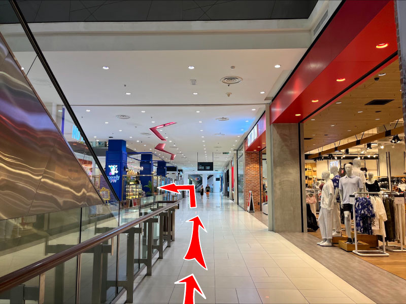 Proceed straight and take the escalator to the 2nd floor.